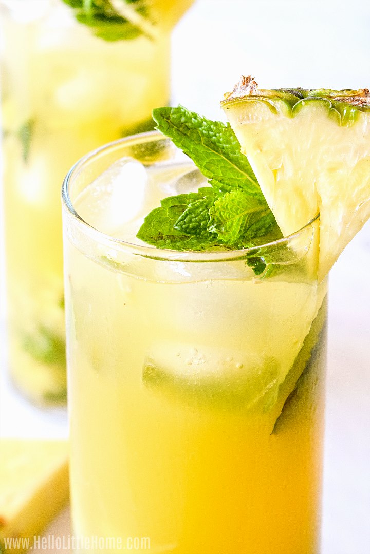 A closeup of the finished drink garnished with a pineapple wedge and fresh mint.