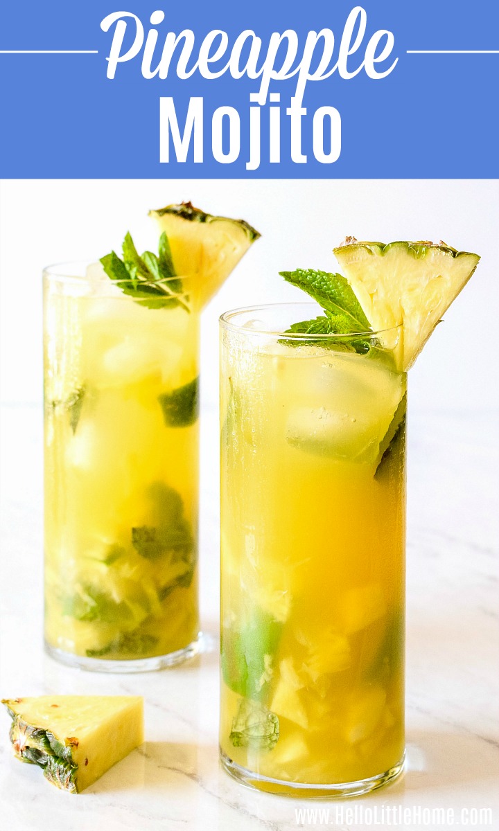 Two Pineapple Mojitos and a wedge of pineapple on a marble counter.