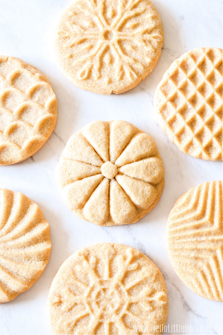 Sugar cookies with different patterns arranged on a marble counter.