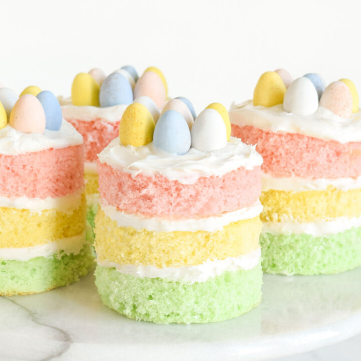 Four Mini Easter Cakes on a marble cake stand.