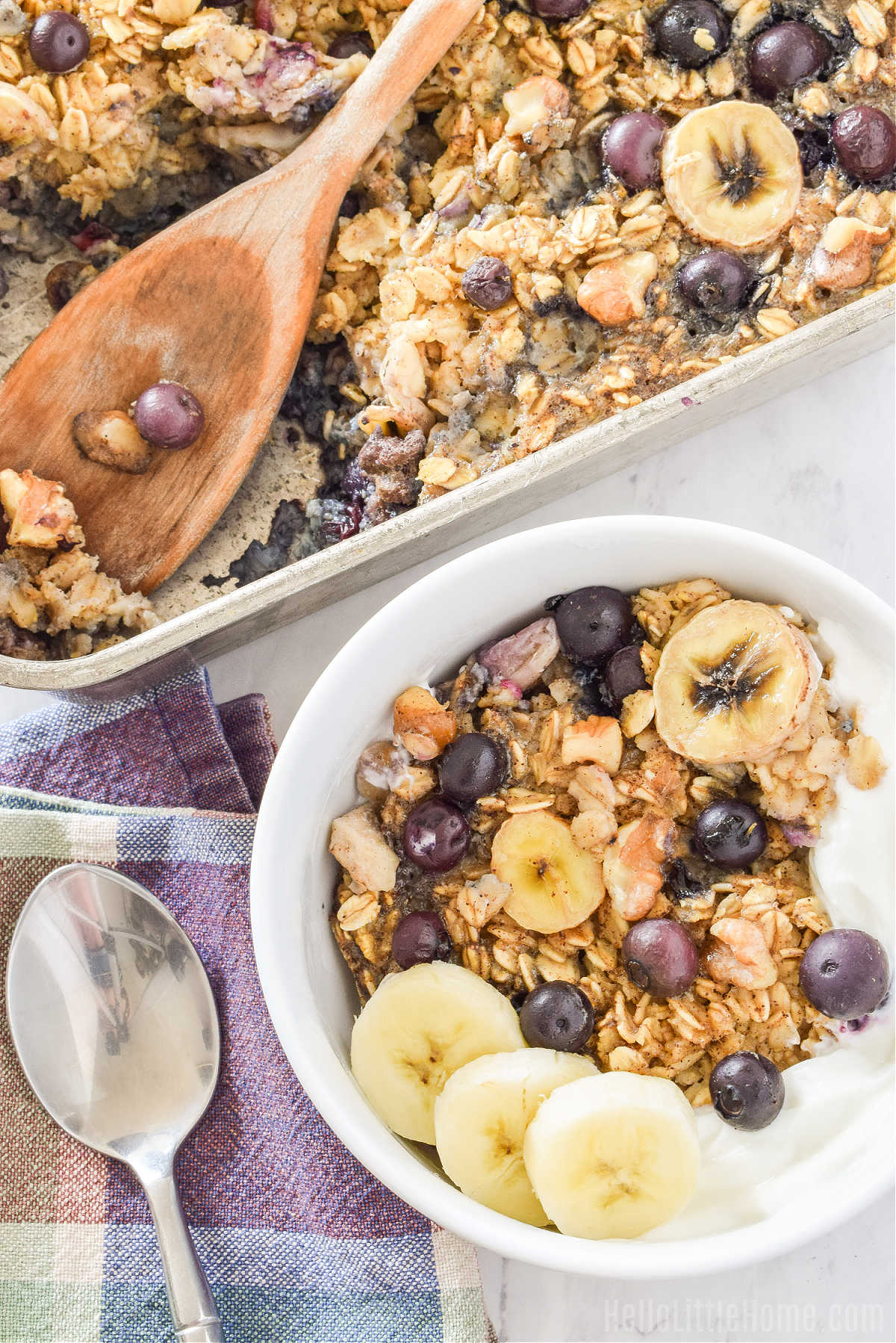 A bowl of Blueberry Banana Baked Oatmeal next to the baking pan.