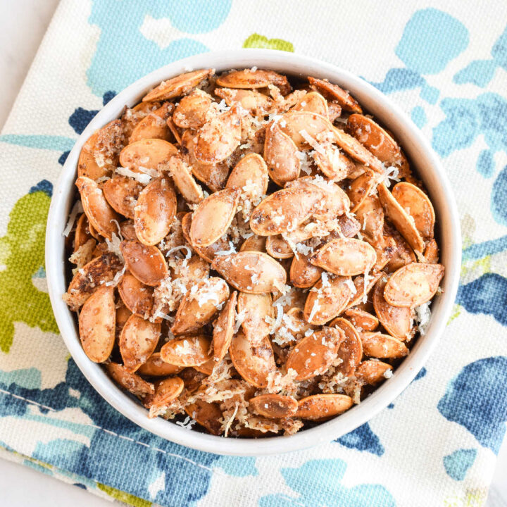 Garlic Parmesan Pumpkin Seeds served in a bowl on a colorful napkin.