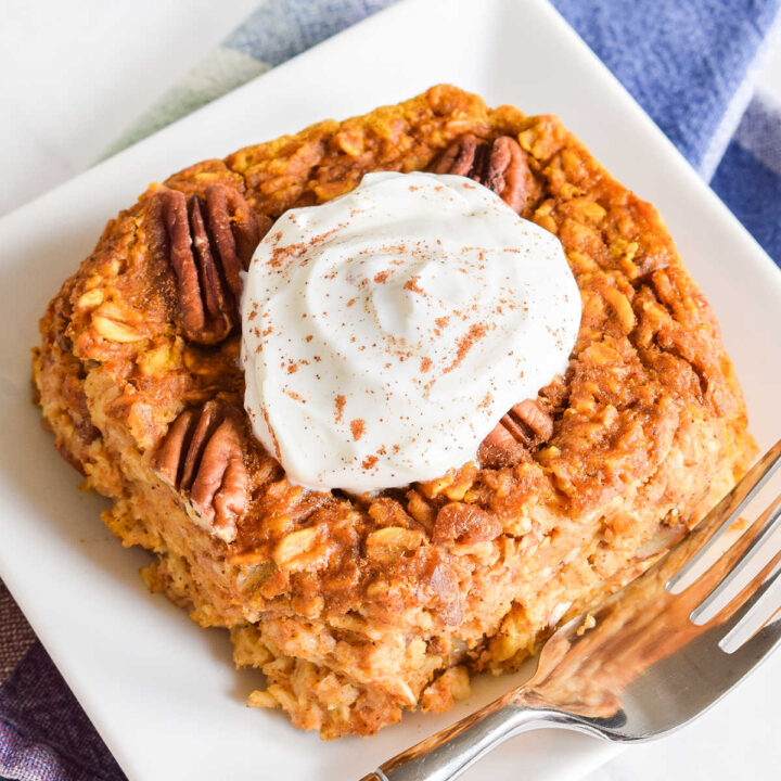 Pumpkin Baked Oatmeal topped with yogurt on a small white plate.