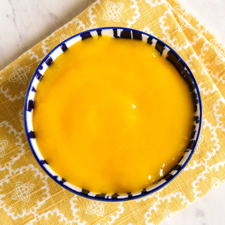 A bowl of Mango Puree on a yellow napkin.