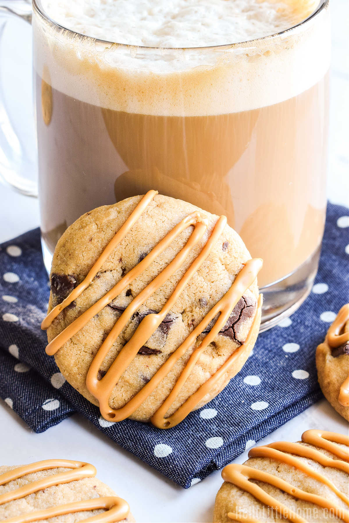 A Coffee Chocolate Cookie leaning against a latte.