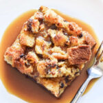 A piece of Panettone Bread Pudding and a fork on a white plate.