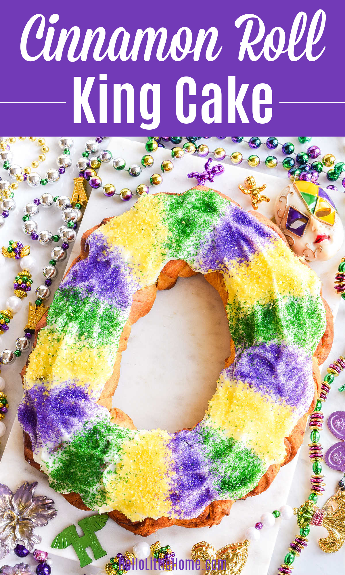 A Cinnamon Roll King Cake surrounded by Mardi Gras Beads and doubloons.