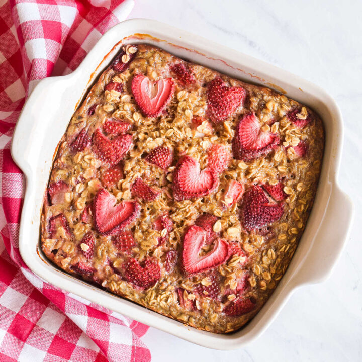 A pan of Strawberry Baked Oatmeal next to a checked napkin.
