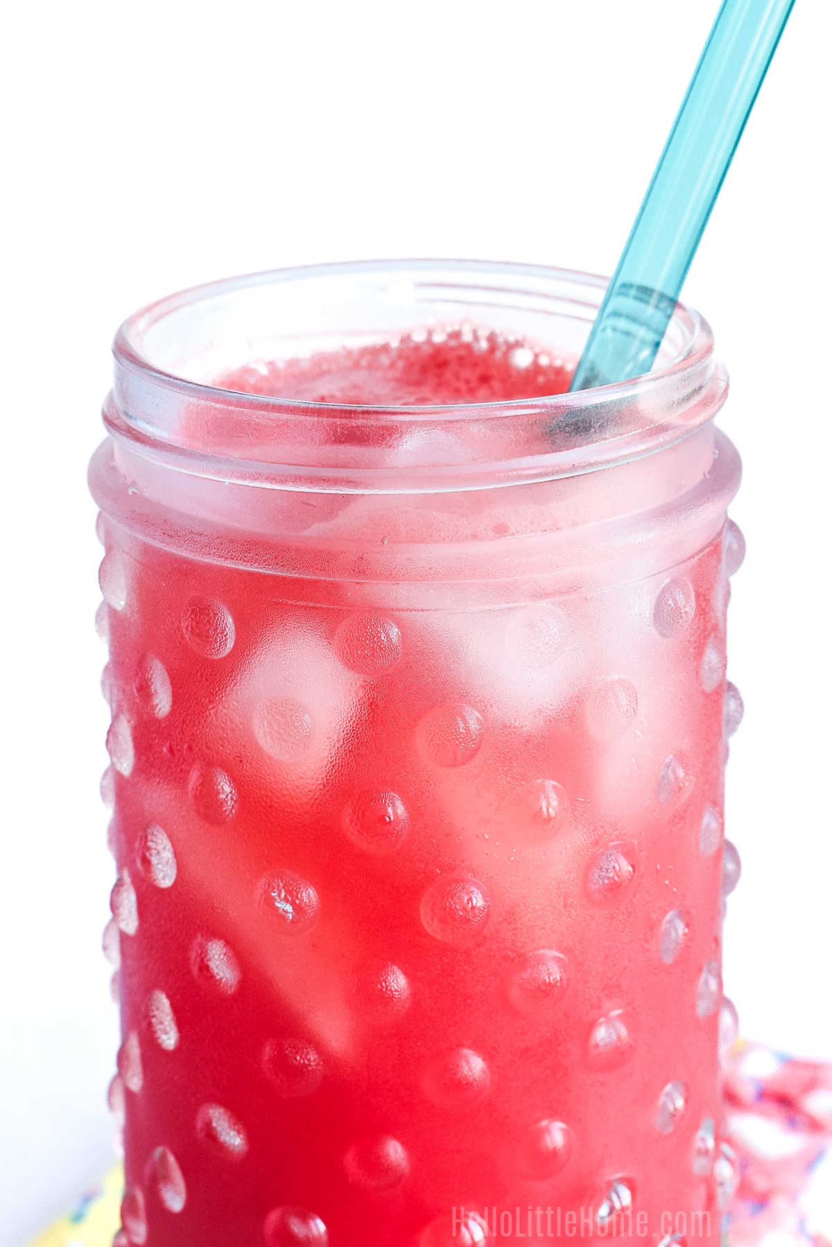Closeup of an Agua Fresca de Sandia served in a tall glass with a straw.