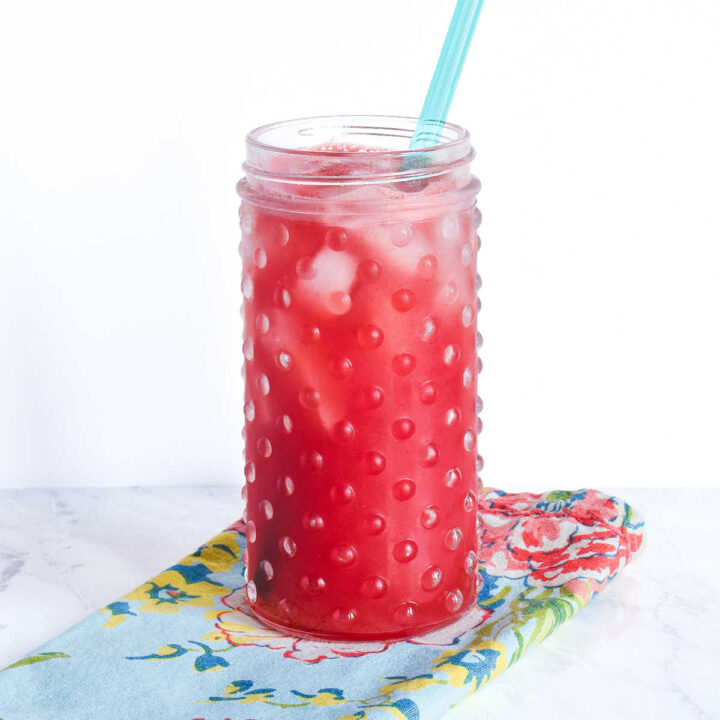 A Watermelon Agua Fresca drink served in a tall glass with a straw.