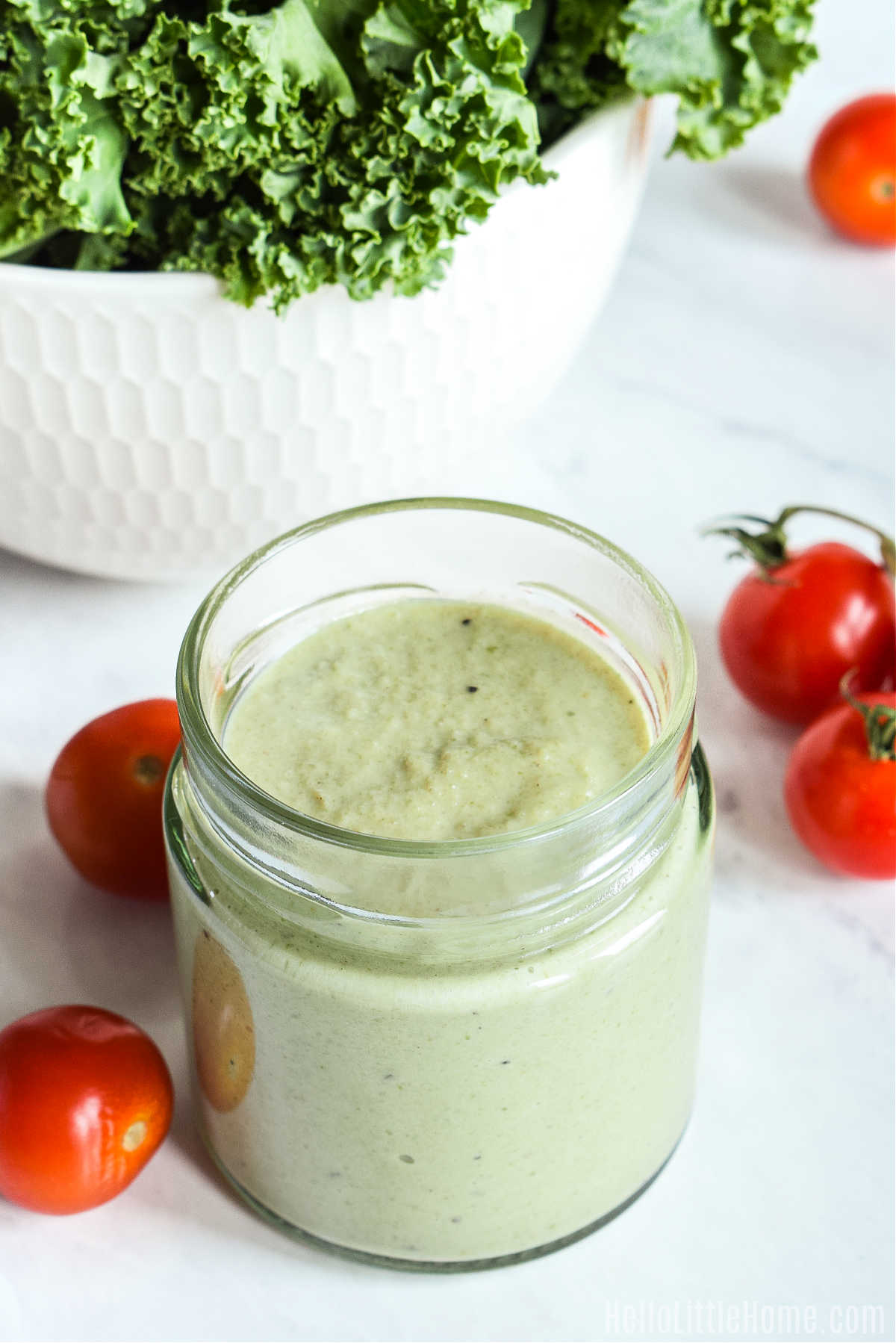 An overhead image of the finished dressing and cherry tomatoes on a marble counter.
