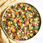 A bowl of Roasted Pumpkin Quinoa Salad served next to a yellow napkin.