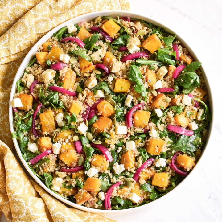 A bowl of Roasted Pumpkin Quinoa Salad served next to a yellow napkin.