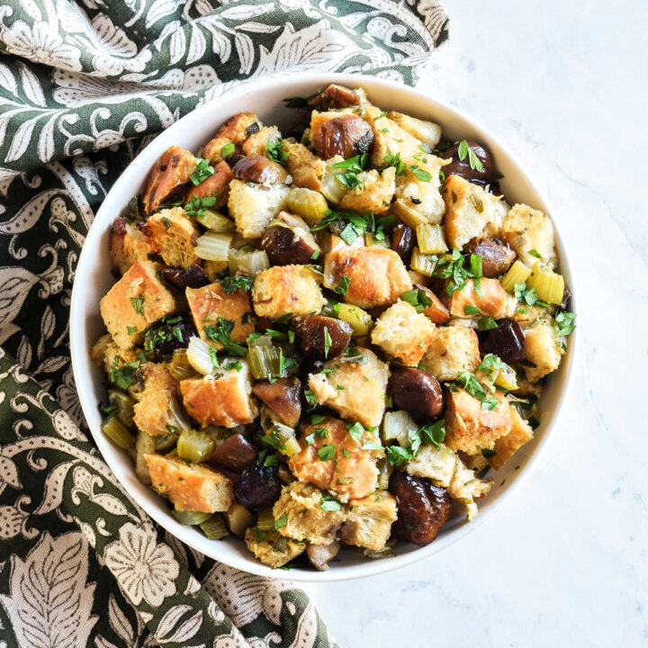 A bowl of homemade Chestnut Stuffing served next to a patterned napkin.