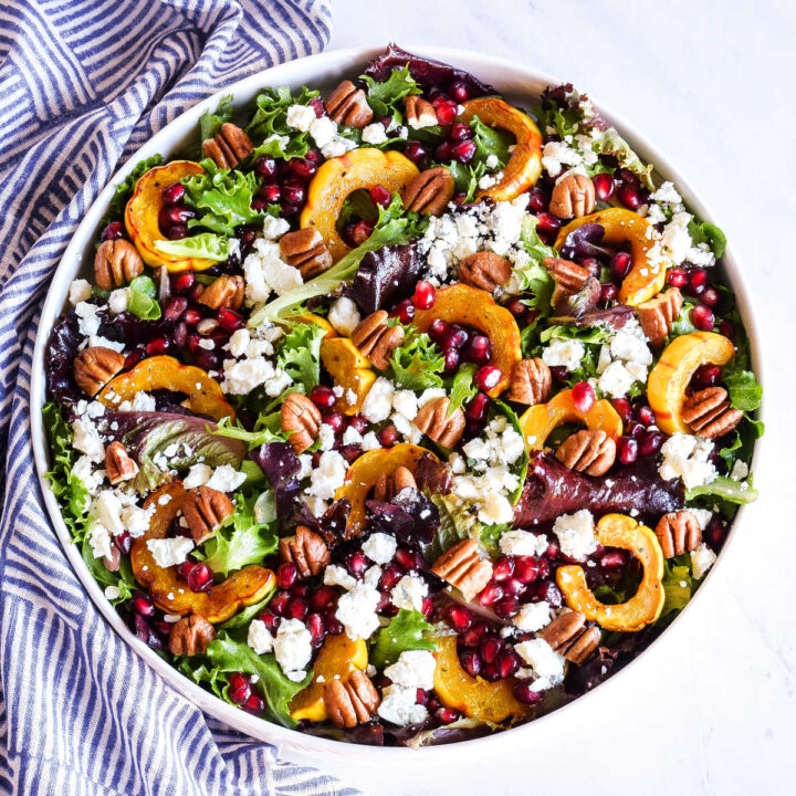 A bowl of Delicata Squash Salad served next to a striped napkin.