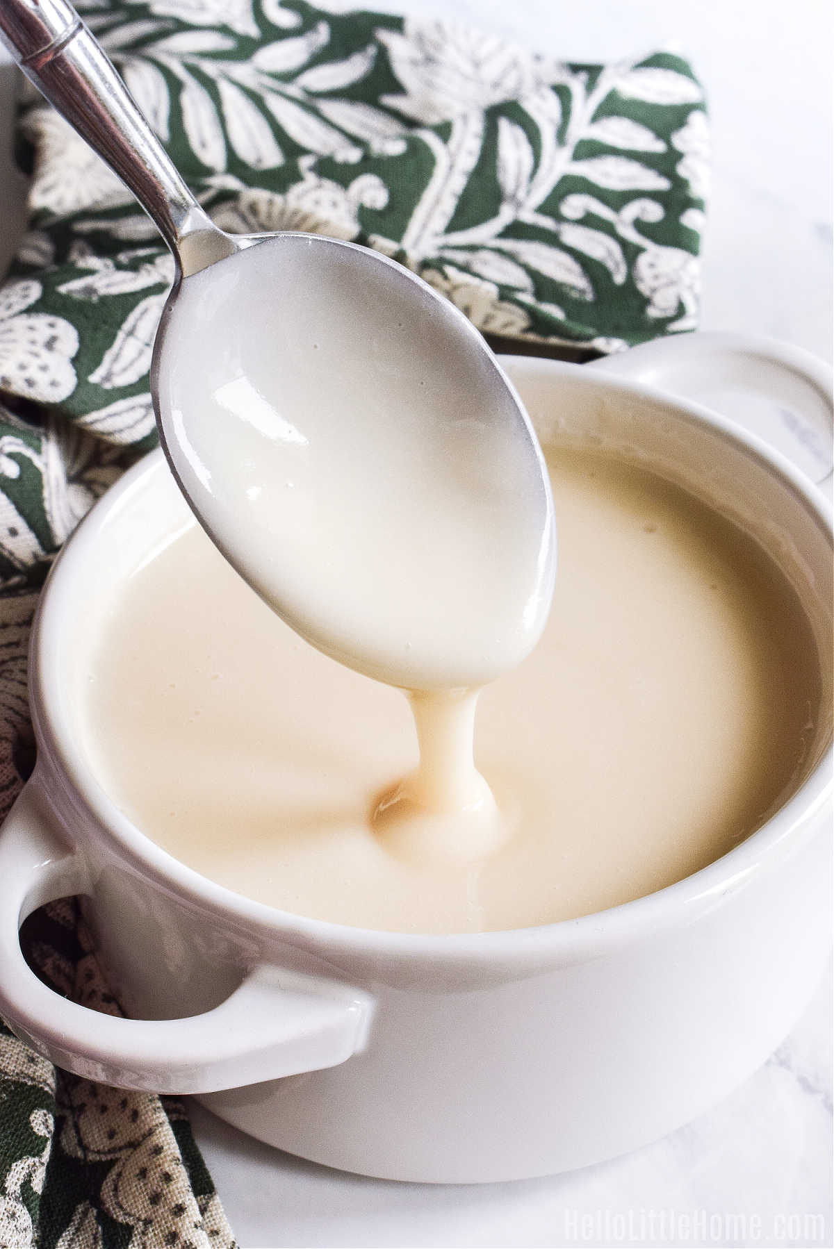 A spoon drizzling the Confectioner's Sugar Glaze into a bowl.