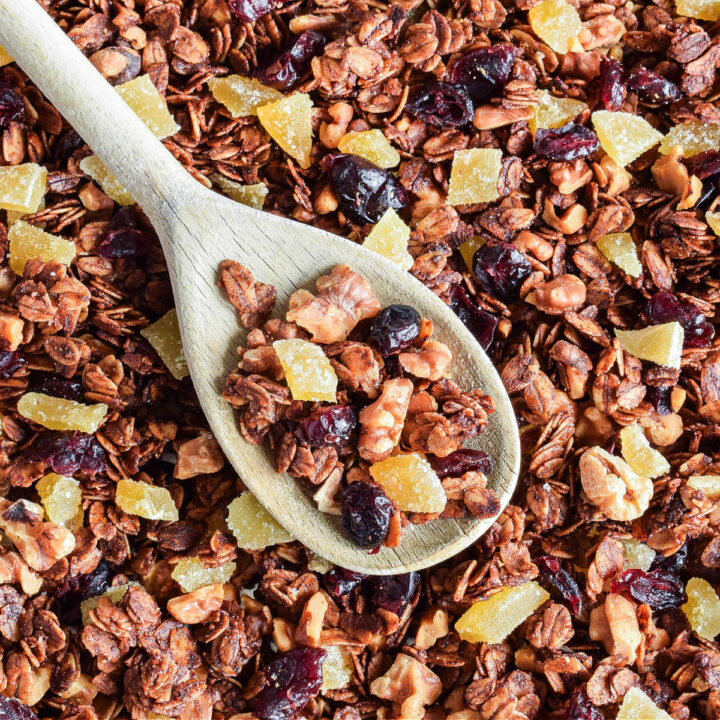 Closeup of Gingerbread Granola with a wood spoon in it.