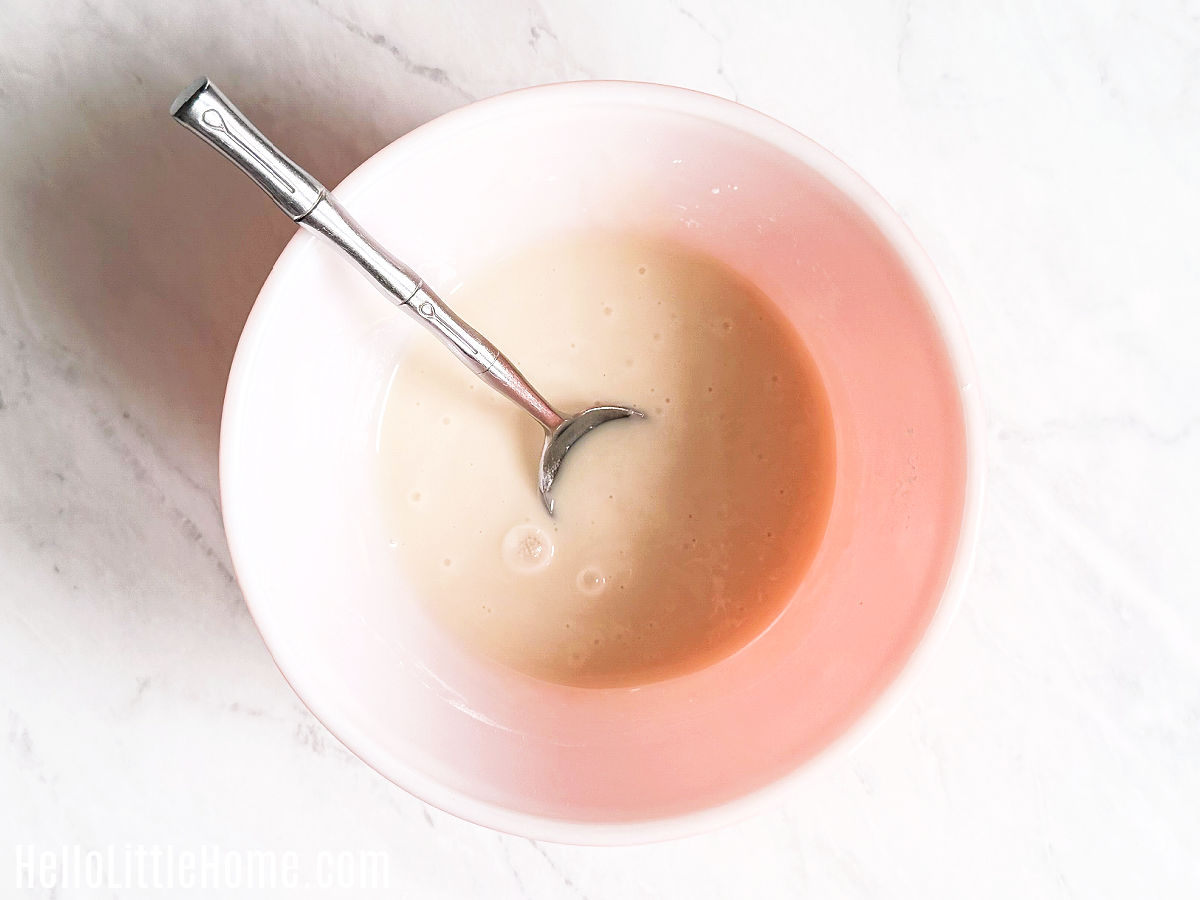 A spoon mixing the ingredients together in a large bowl.