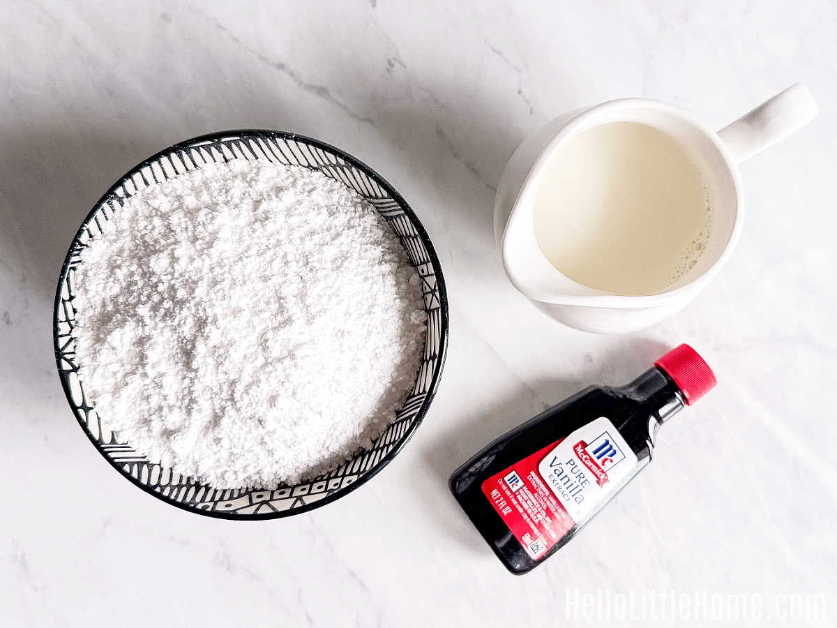 Powdered Sugar Glaze ingredients gathered together on a marble counter.