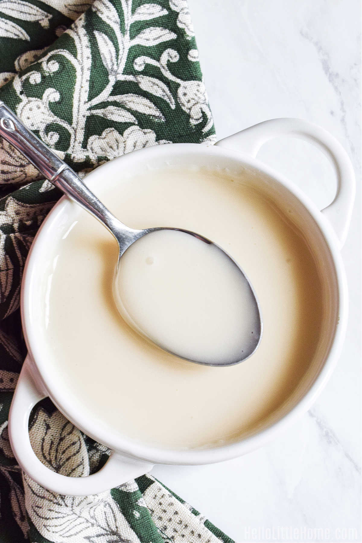 A bowl of the finished icing with a spoon in it.
