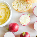 Radishes and butter with salt served on a marble table.