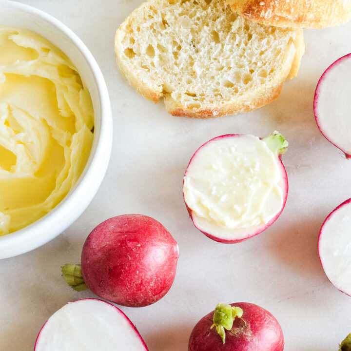 Radishes and butter with salt served on a marble table.
