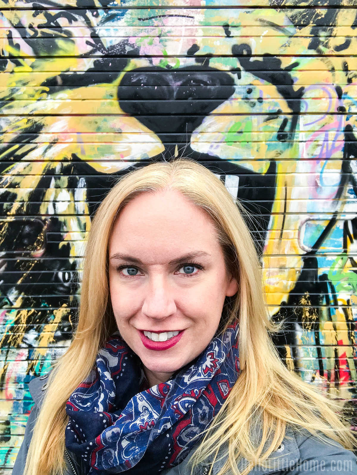 Ginnie standing in front of a mural in the Deep Ellum neighborhood.