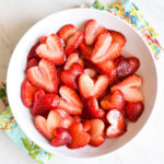 A bowl of Macerated Strawberries served on a colorful napkin.