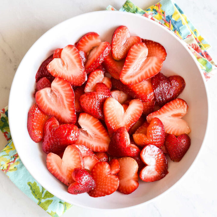 A bowl of Macerated Strawberries served on a colorful napkin.