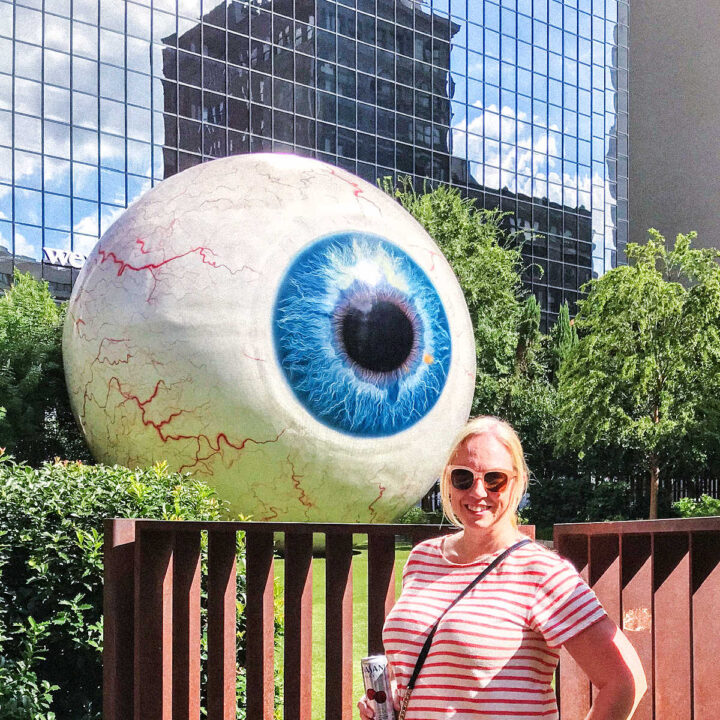Ginnie standing by The Eye sculpture, one of the best things to do in Dallas.