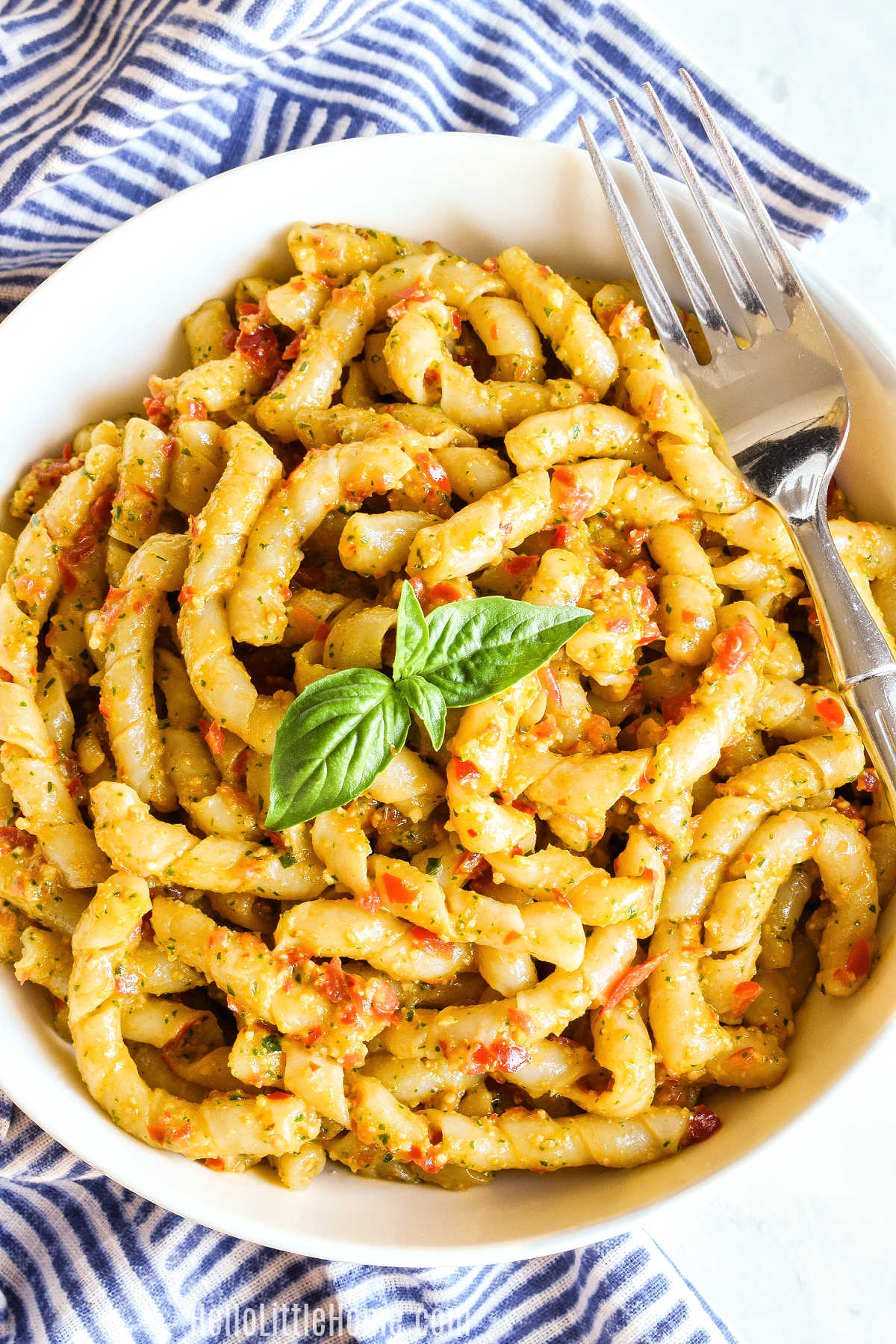 A bowl of Busiate alla Trapanese with a fork resting on the rim.