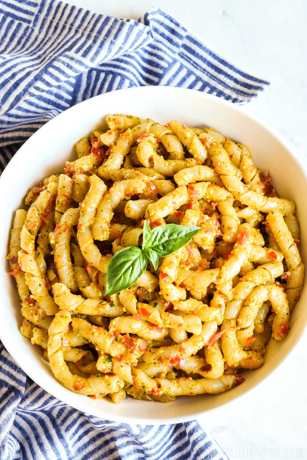 A bowl of the finished pasta served with a striped napkin.