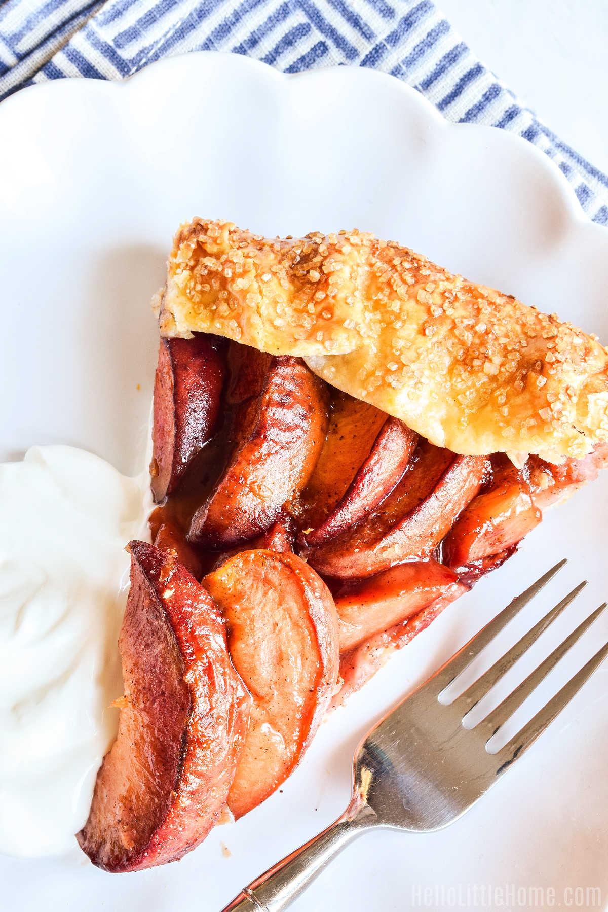 A slice of the galette served with whipped cream and a fork.