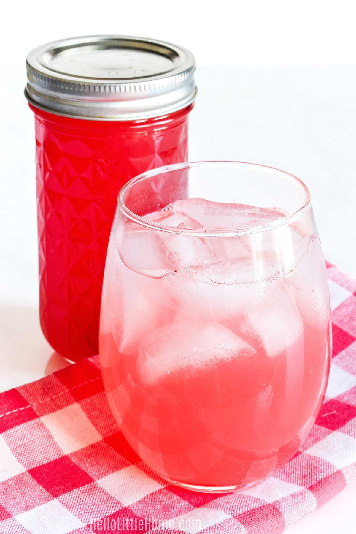 A watermelon drink and a jar of the homemade syrup behind it.