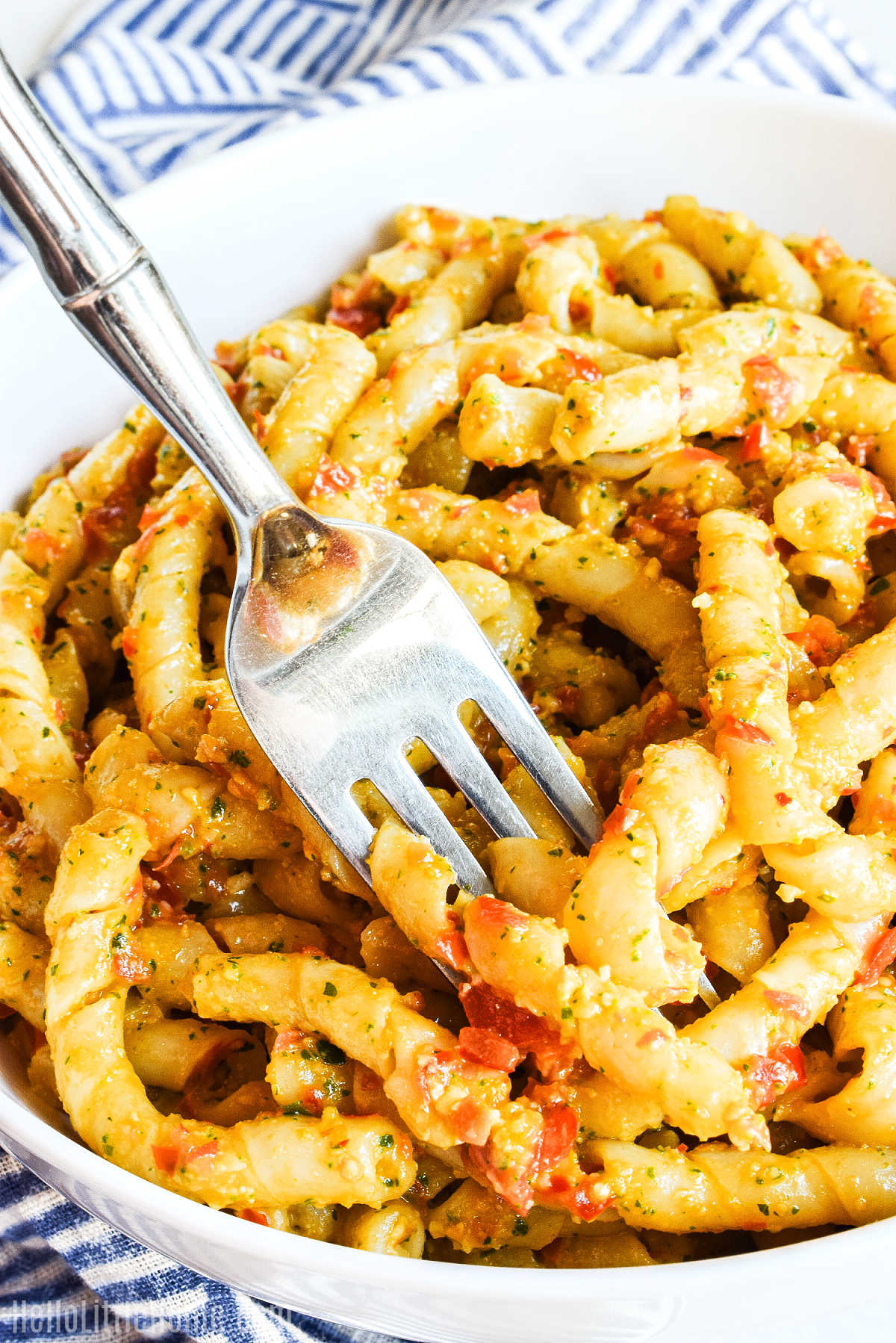 A fork spearing a bite of Pasta alla Trapanese.
