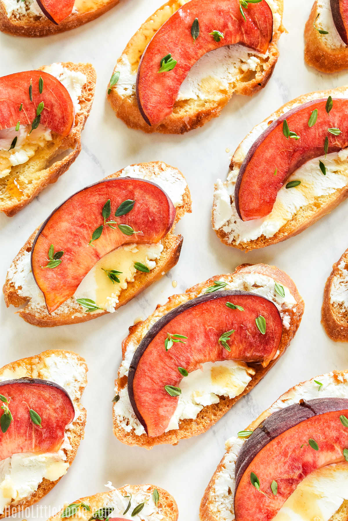 Peach Crostini arranged on a marble counter.