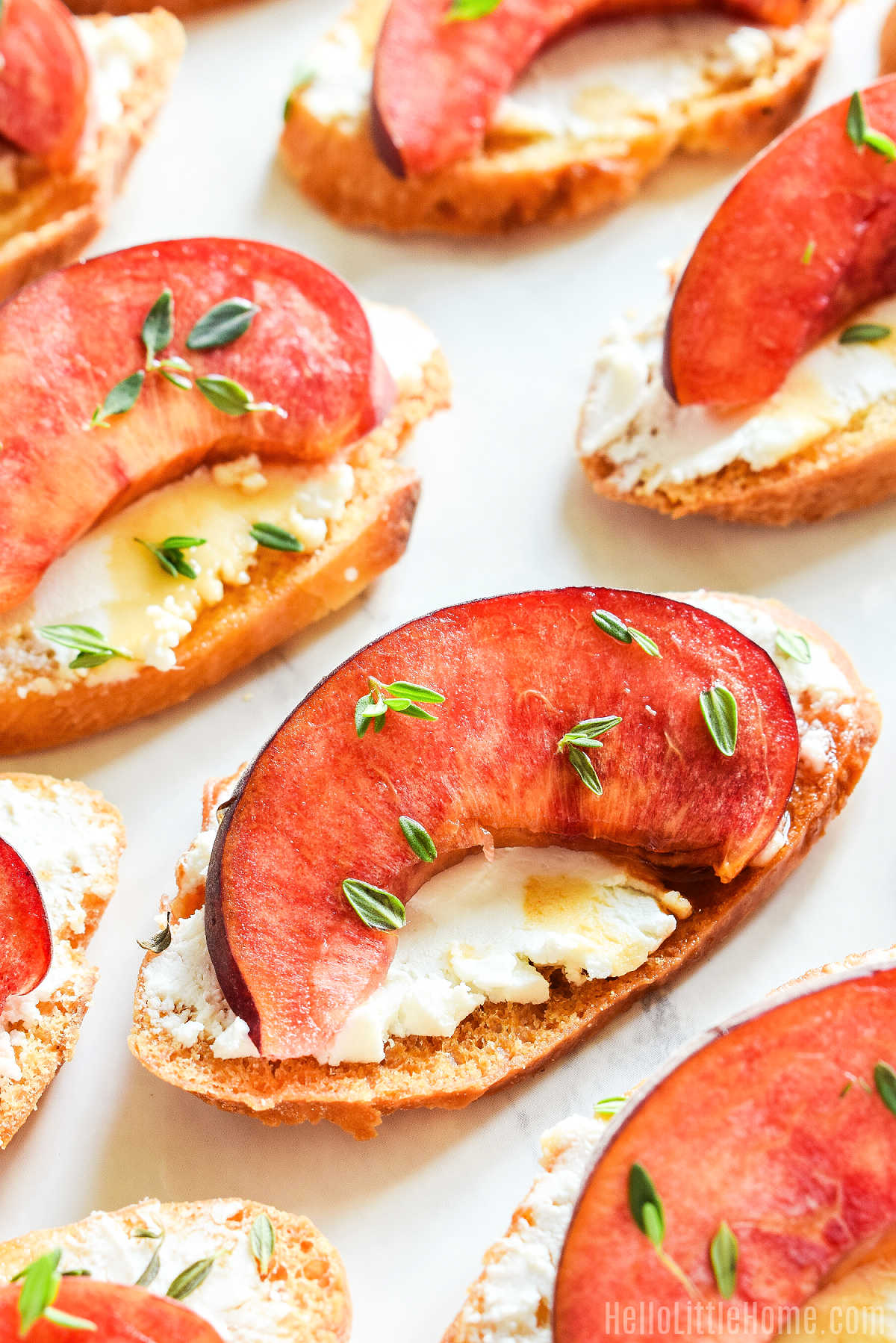 The finished Peach Goat Cheese Crostini arranged on a marble counter.