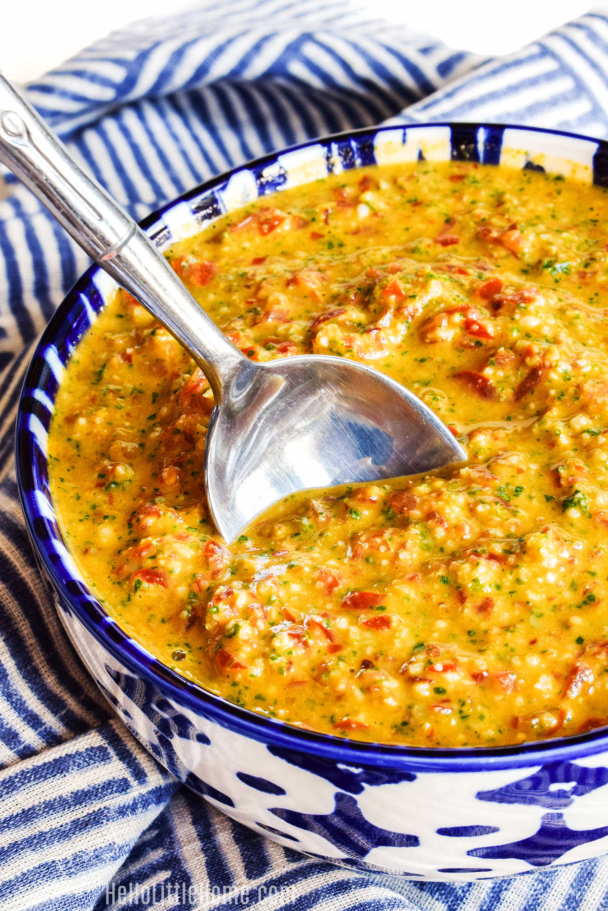 A spoon stirring a bowl of the Sicilian Pesto Sauce.