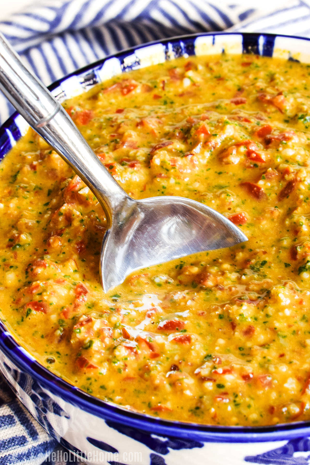 A spoon stirring a bowl of the Trapani Pesto.