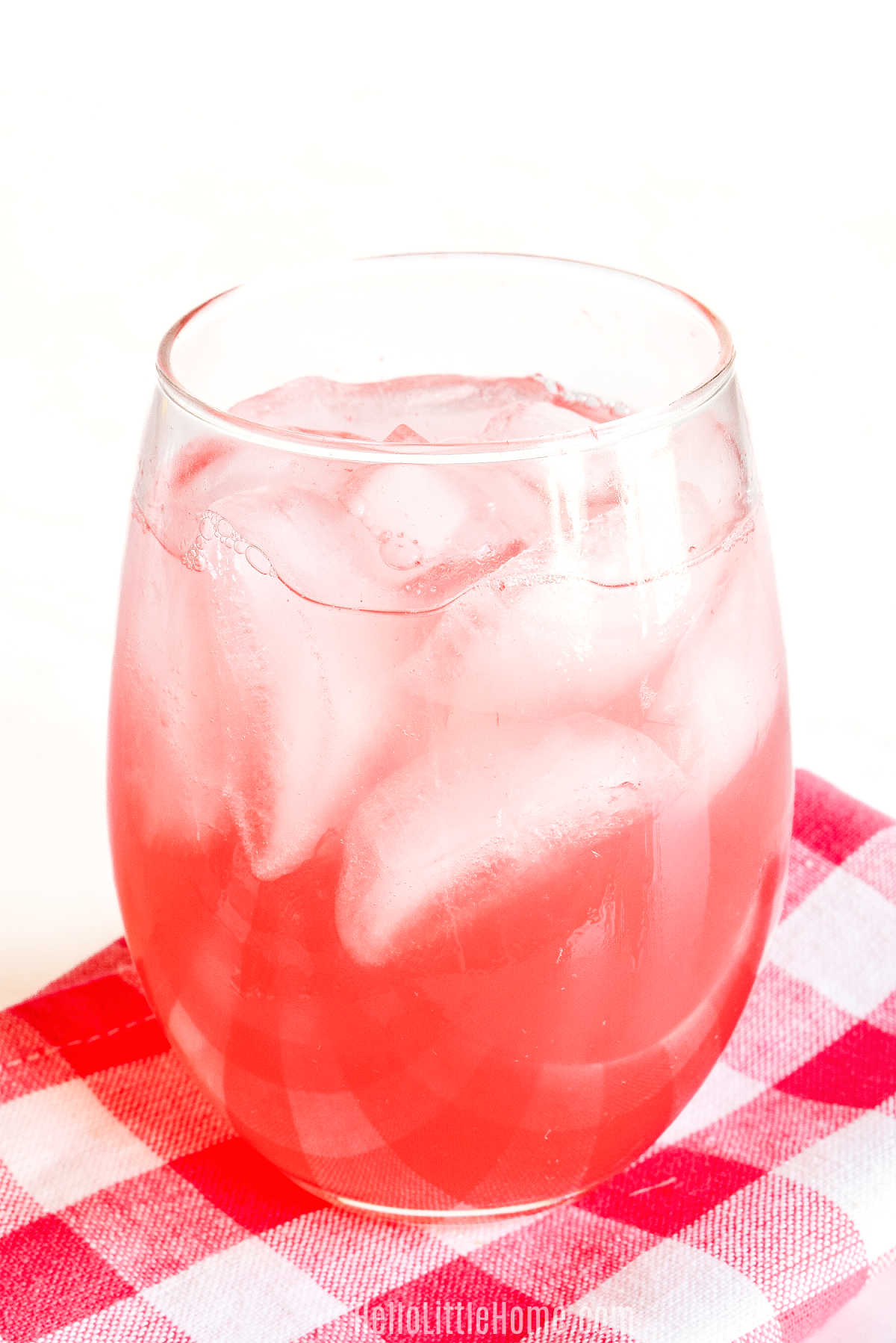 Homemade Watermelon Soda served in a glass on a checked napkin.