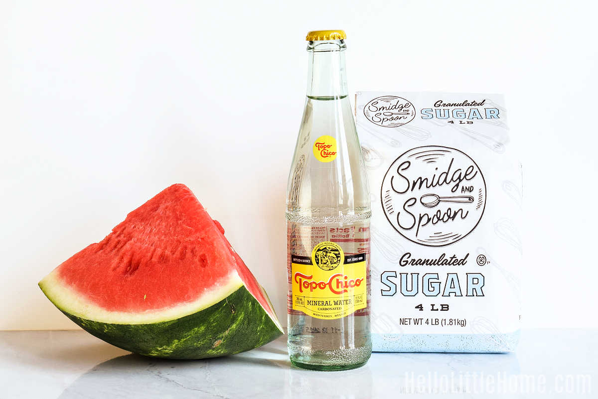 Ingredients for homemade Watermelon Soda arranged on a marble counter.