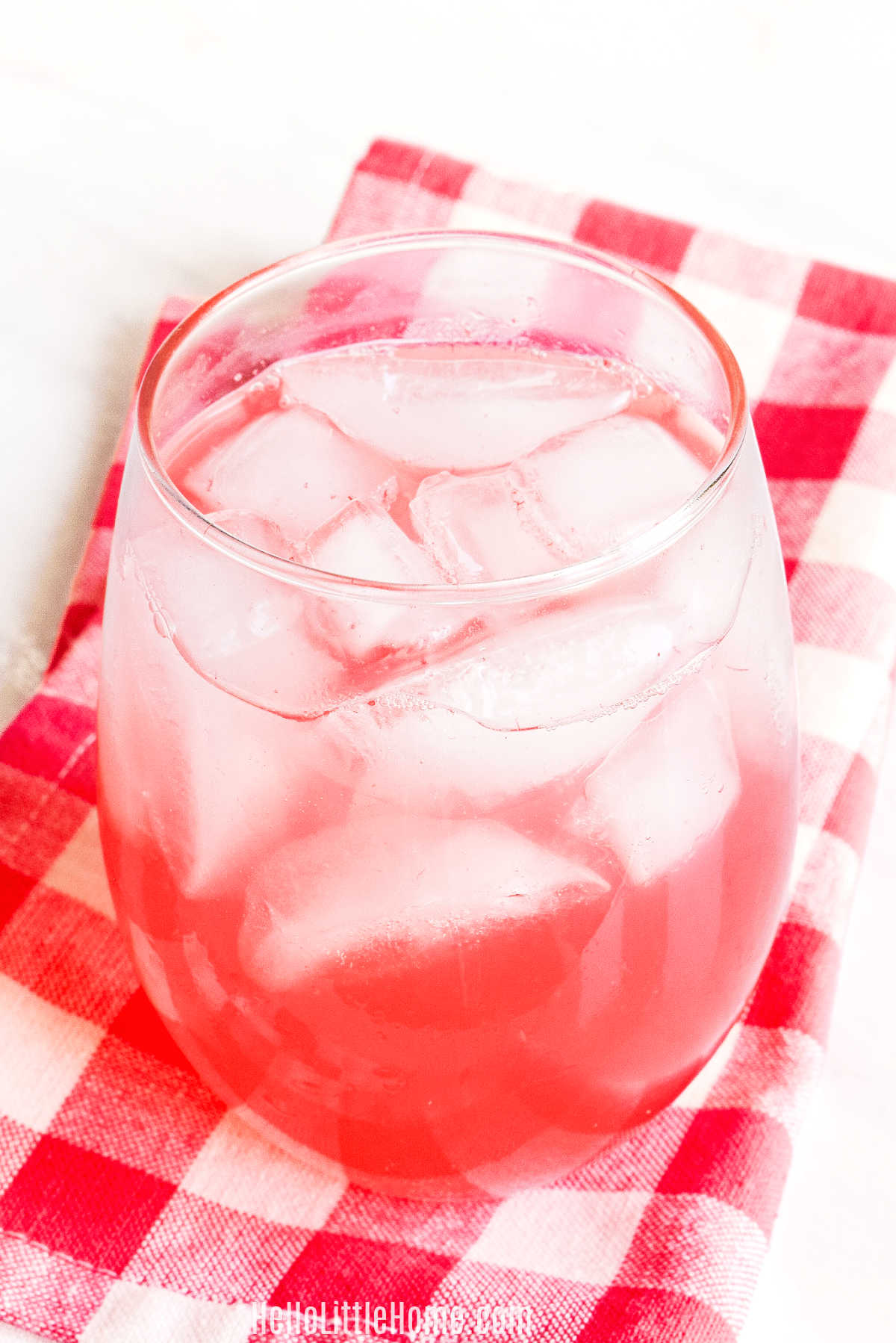 A glass of the Watermelon Soft Drink on a checked napkin.