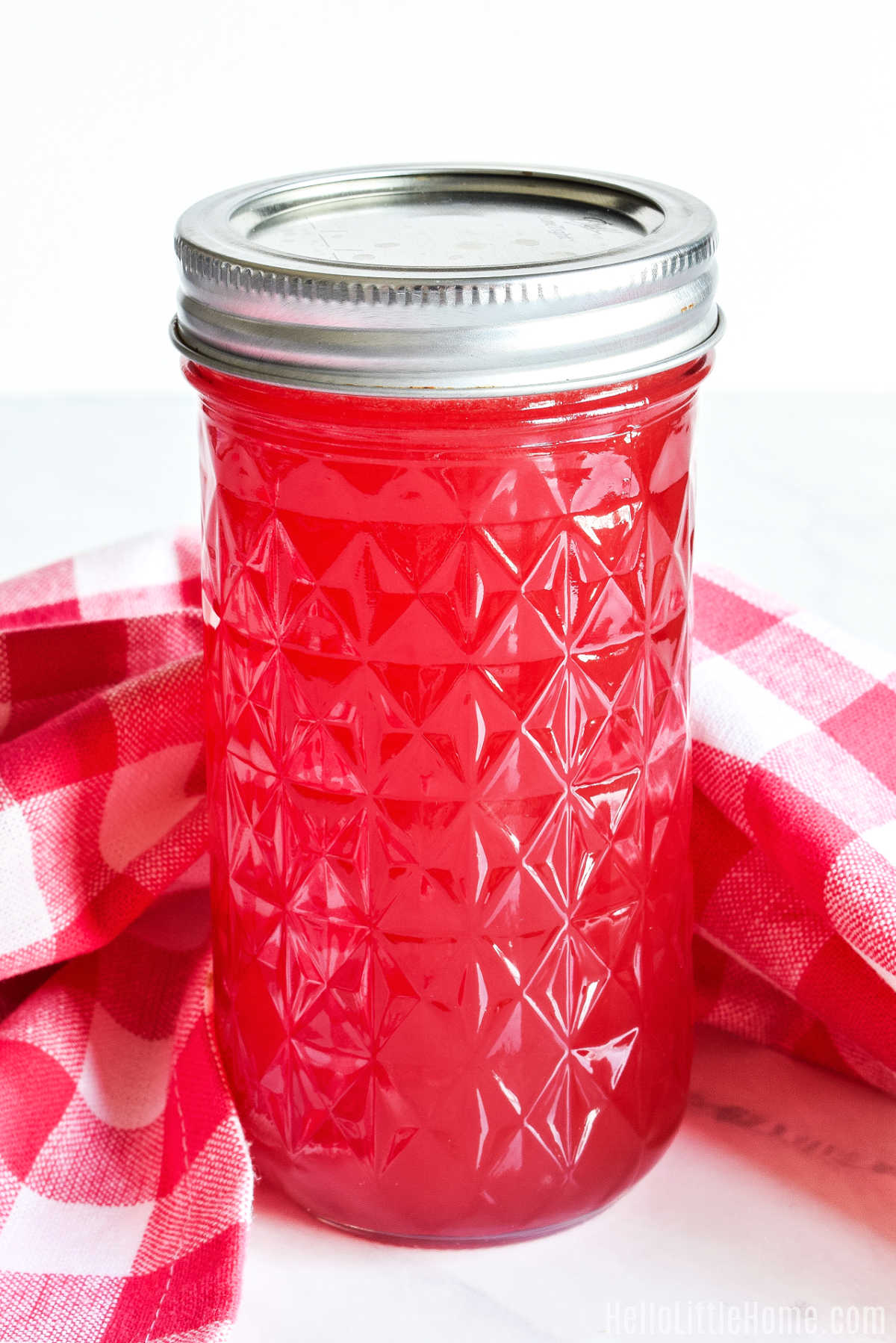 A jar of the finished recipe with a checked napkin behind it.