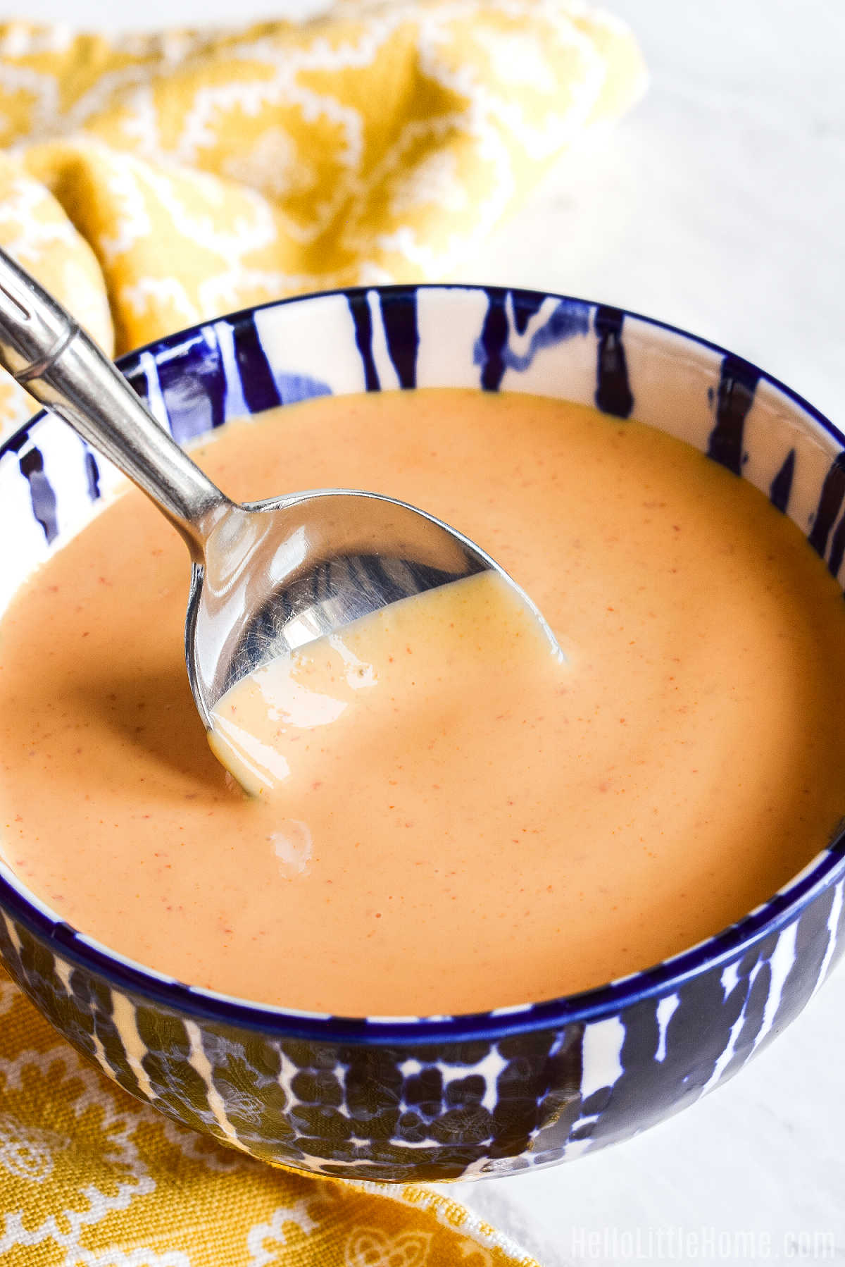 A spoon stirring a bowl of the DIY mayo sauce.