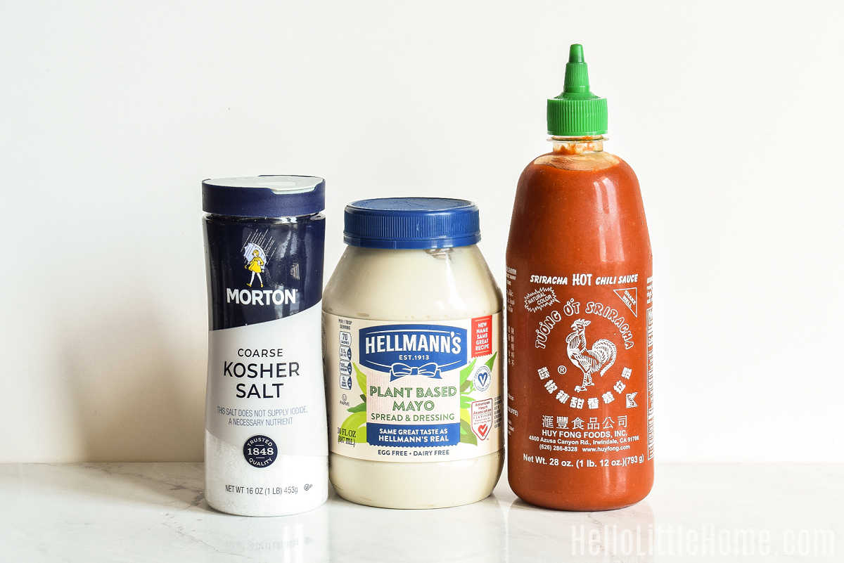 Sriracha Mayonnaise ingredients gathered together on a marble counter.