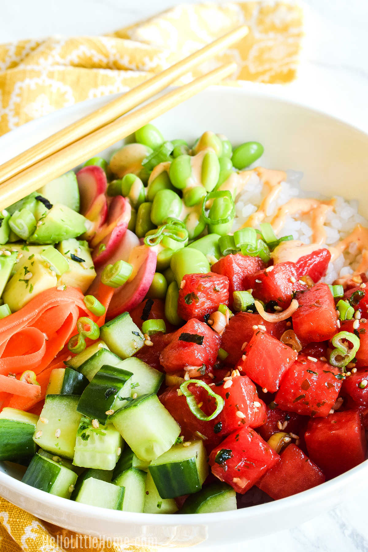 A Watermelon Poke Bowl with chopsticks resting on the bowl's rim.
