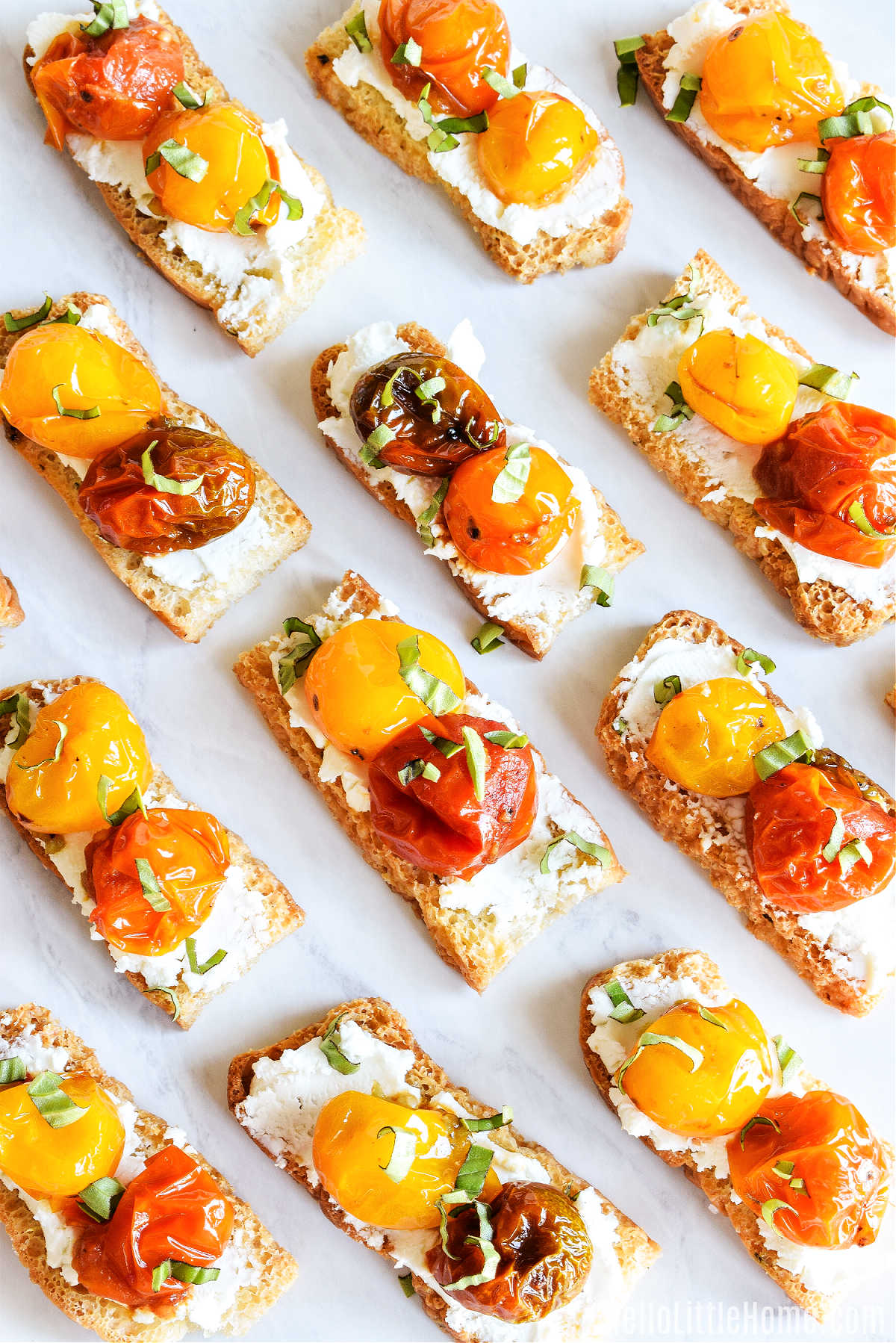 A tray of the finished Focaccia Toasts topped with cheese and tomatoes.