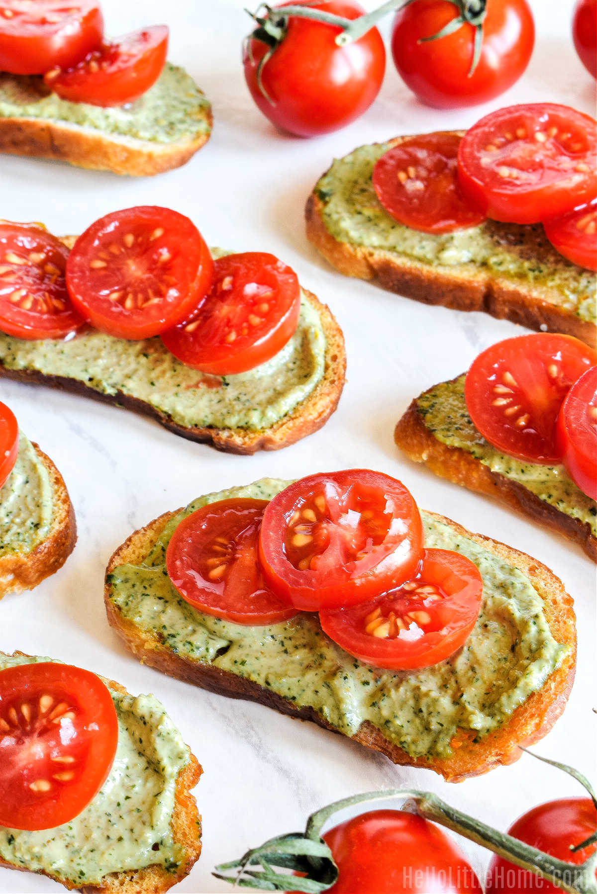 The crostini appetizer and cherry tomatoes on a marble tray.