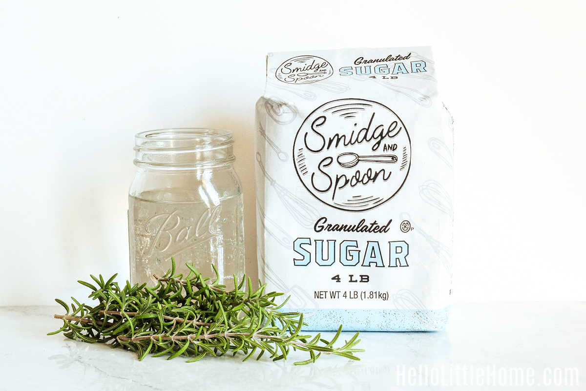 Rosemary Simple Syrup ingredients gathered together on a marble counter.
