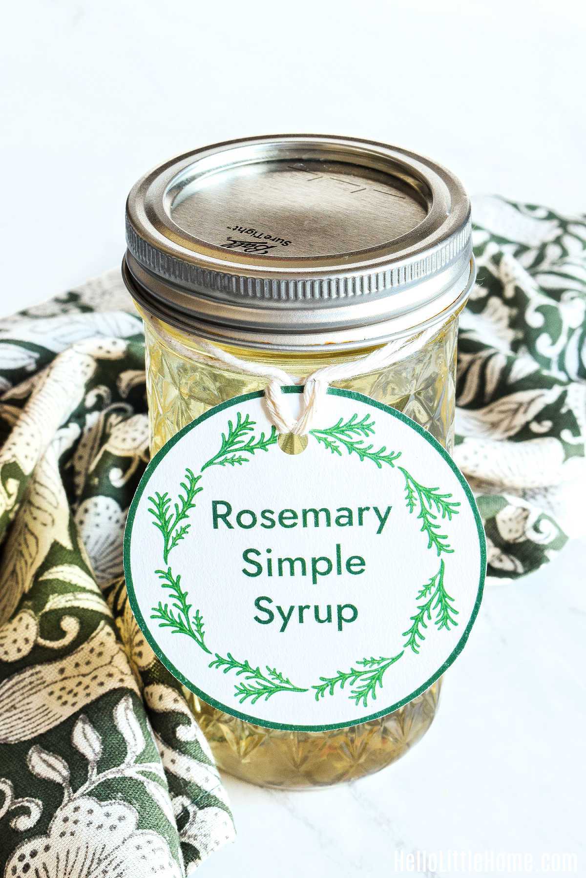 A jar of homemade Rosemary Syrup decorated with a cute label.